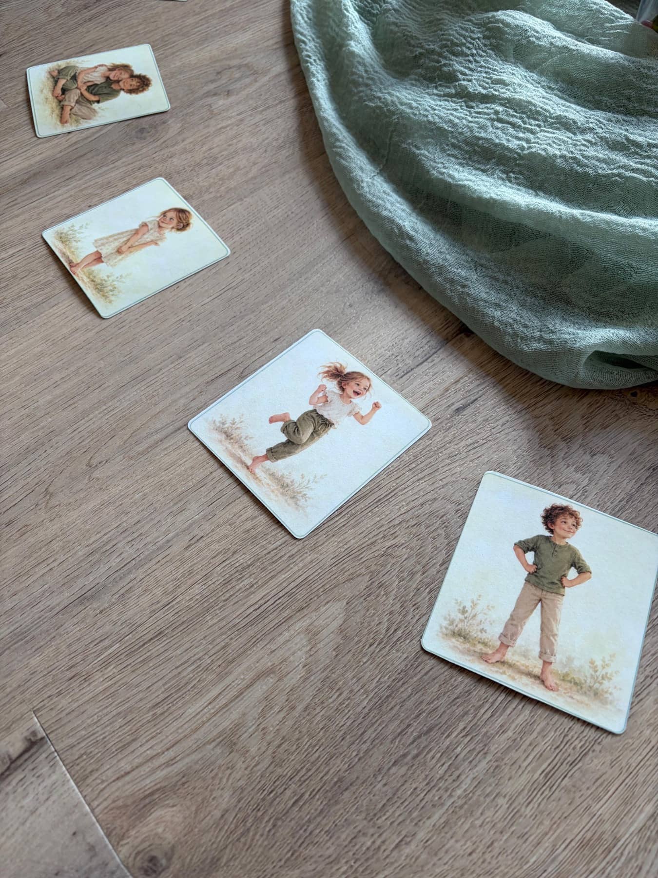 Bildkarten aus dem StrongKids-Kurs auf dem Holzboden neben einem mintgrünen Tuch