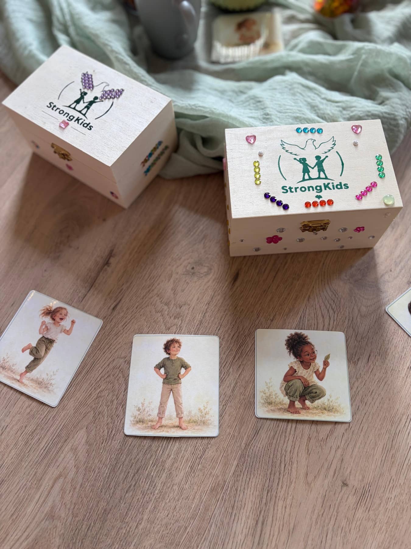 Zwei StrongKids-Schatztruhen mit Glitzersteinen und Bildkarten im Kursraum in Weyhe